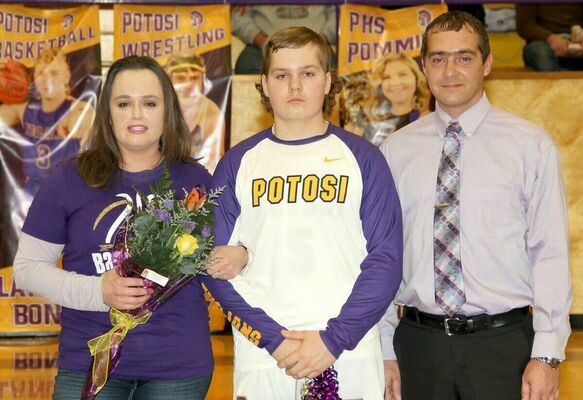 SENIOR TROJAN CORY EMILY has played 4 years of basketball and baseball for Potosi and escorted his mom and dad, Heather and Cory Emily at the Senior Night Celebration on Friday at the P.H.S. gym.