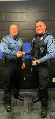 City Police Chief Michael Gum congratulates Officer Jacob Jenkins